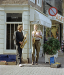 66791 Afbeelding van twee straatmuzikanten, met op de achtergrond de voor- (rechts) en linkerzijgevel van het pand ...